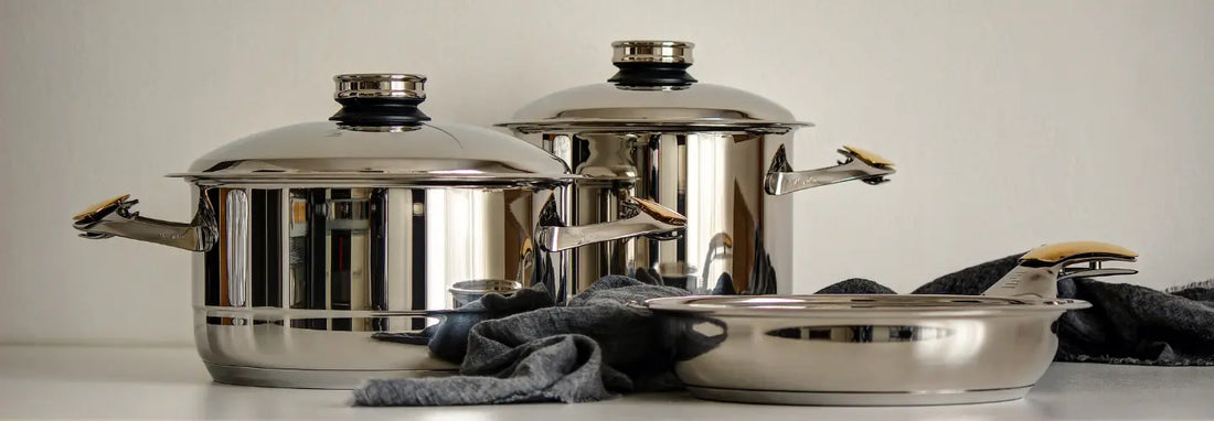 MasterPiece stainless pots and pans arranged on a modern New Zealand kitchen bench
