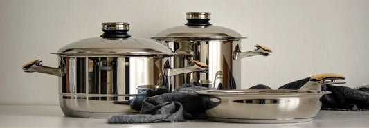 MasterPiece stainless pots and pans arranged on a modern New Zealand kitchen bench
