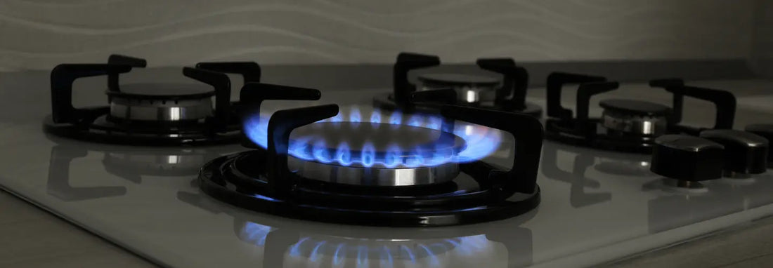 Stainless steel cookware centred over a blue gas flame with the flame contained beneath the base