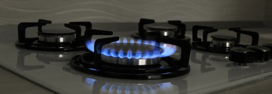 Stainless steel cookware centred over a blue gas flame with the flame contained beneath the base