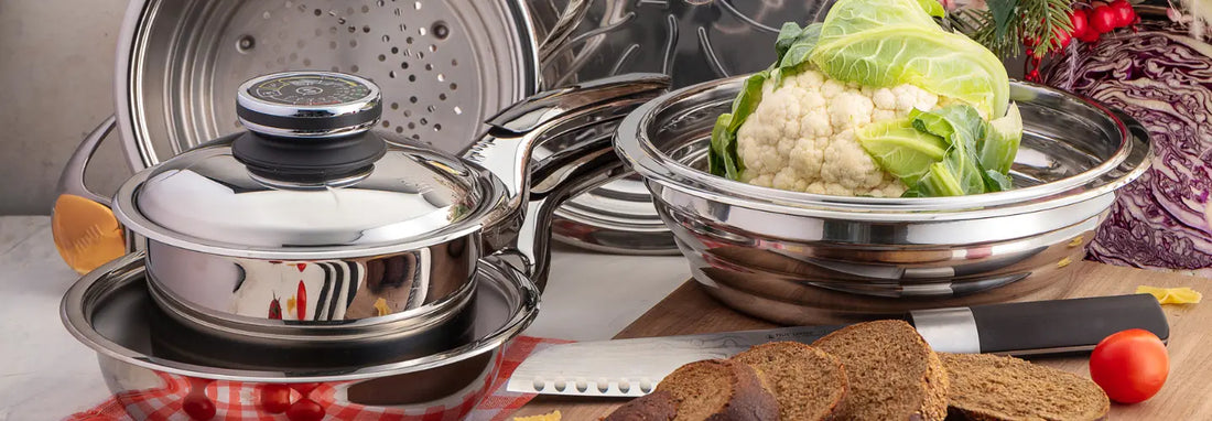 Stainless steel and cast iron cookware beside an induction hob with a small magnet used to check induction compatibility.