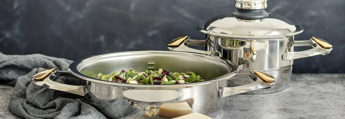 Stainless steel pots and pans heating on a modern induction cooktop.